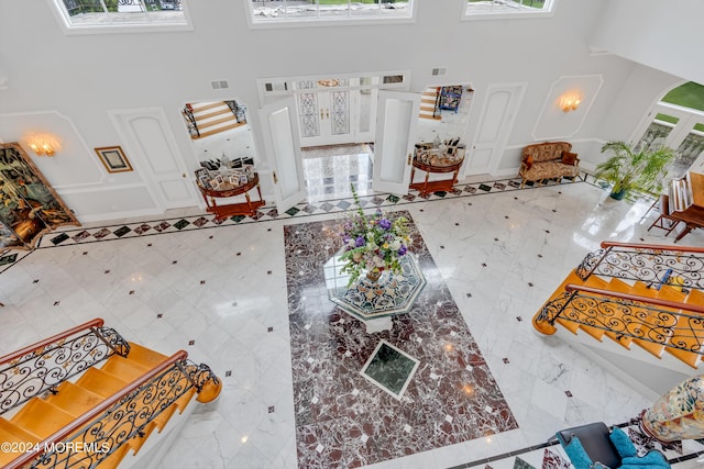 tiled living room with a wealth of natural light and a high ceiling