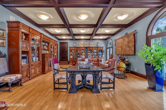 dining room featuring beamed ceiling, light wood-type flooring, and coffered ceiling