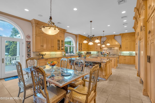 tiled dining room with a chandelier and ornamental molding