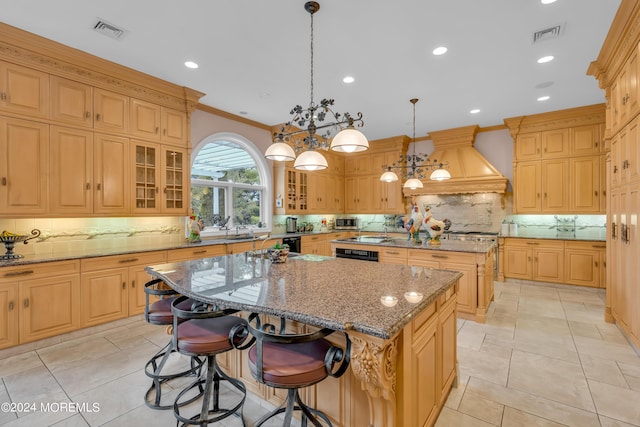 kitchen featuring a center island, hanging light fixtures, light stone counters, backsplash, and custom exhaust hood