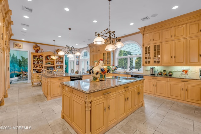 kitchen featuring a kitchen island with sink, crown molding, hanging light fixtures, light stone countertops, and kitchen peninsula