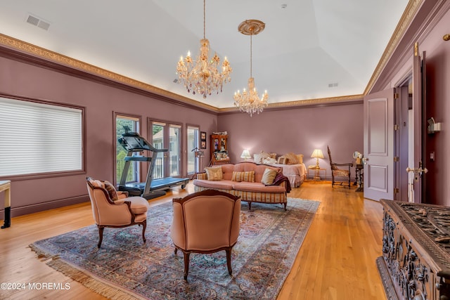 interior space featuring a raised ceiling, a notable chandelier, light wood-type flooring, vaulted ceiling, and ornamental molding