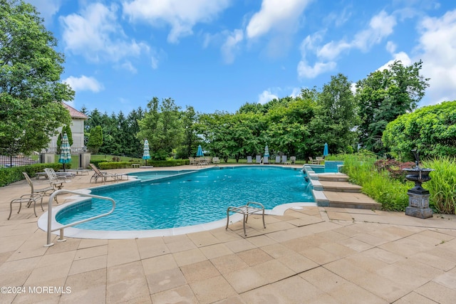 view of pool featuring pool water feature and a patio area