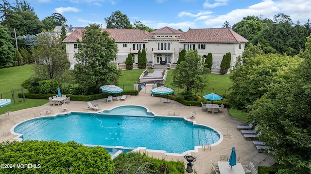 view of pool with a lawn and a patio