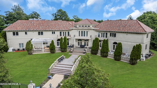 back of property featuring a lawn and a balcony