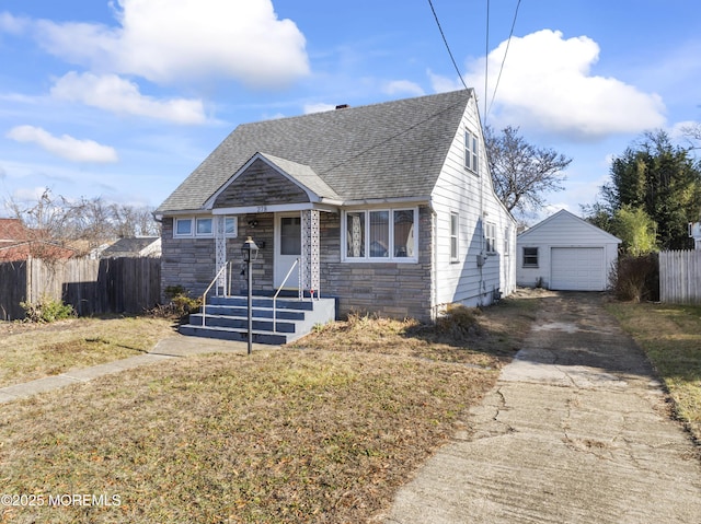 bungalow-style home with a front yard, an outdoor structure, and a garage