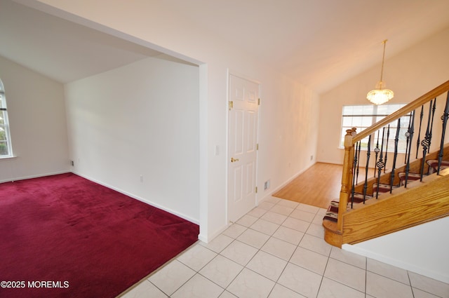 interior space featuring light tile patterned floors, an inviting chandelier, and vaulted ceiling