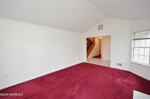 spare room featuring light carpet and lofted ceiling