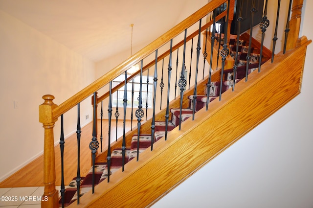 stairs with tile patterned flooring and an inviting chandelier