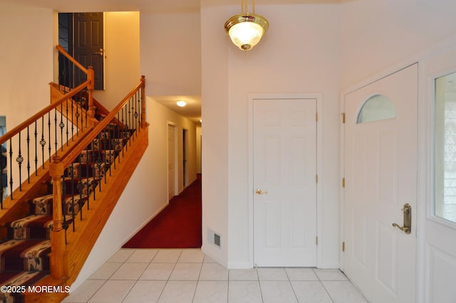 tiled foyer featuring a towering ceiling