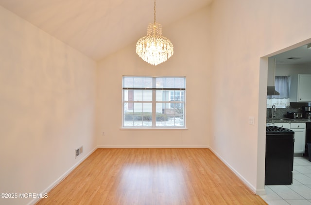 unfurnished dining area featuring sink, light hardwood / wood-style flooring, high vaulted ceiling, and a chandelier