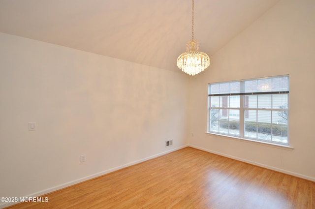 unfurnished room with vaulted ceiling, hardwood / wood-style flooring, and an inviting chandelier