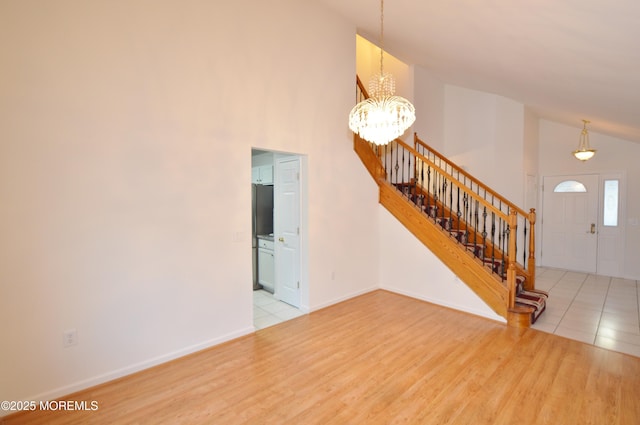 interior space featuring light wood-type flooring, lofted ceiling, and a notable chandelier