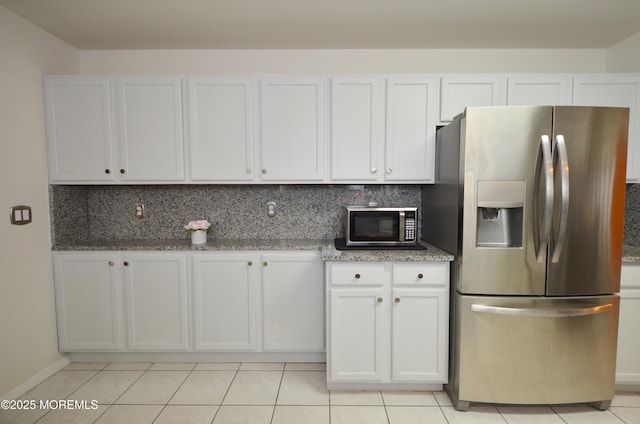 kitchen featuring stone counters, stainless steel fridge with ice dispenser, white cabinets, and light tile patterned flooring