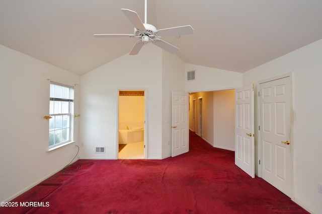 unfurnished bedroom with dark carpet, connected bathroom, vaulted ceiling, and ceiling fan