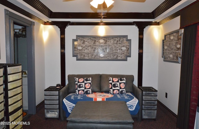 living area with dark colored carpet, ceiling fan, and crown molding