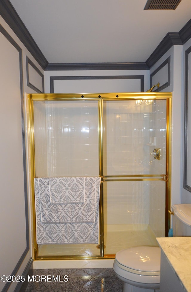 bathroom featuring ornamental molding, vanity, toilet, and a shower with shower door