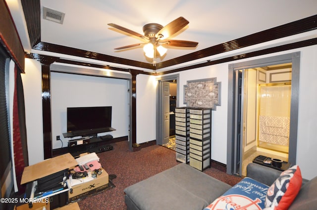 living room with ceiling fan, dark colored carpet, and ornamental molding