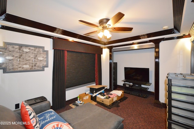 cinema with dark carpet, ceiling fan, and ornamental molding