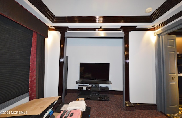 home theater room featuring decorative columns, dark carpet, and crown molding