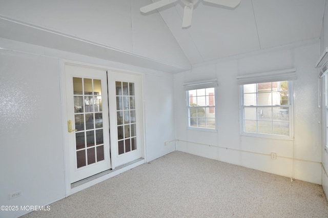 empty room with carpet flooring, ceiling fan, french doors, and vaulted ceiling