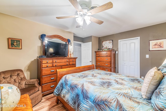 bedroom featuring ceiling fan, light hardwood / wood-style floors, and a closet