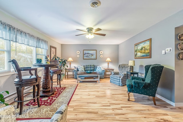 living room featuring ceiling fan and light hardwood / wood-style flooring