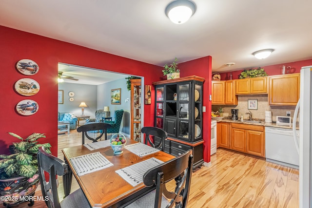 kitchen featuring ceiling fan, sink, tasteful backsplash, light hardwood / wood-style flooring, and white appliances