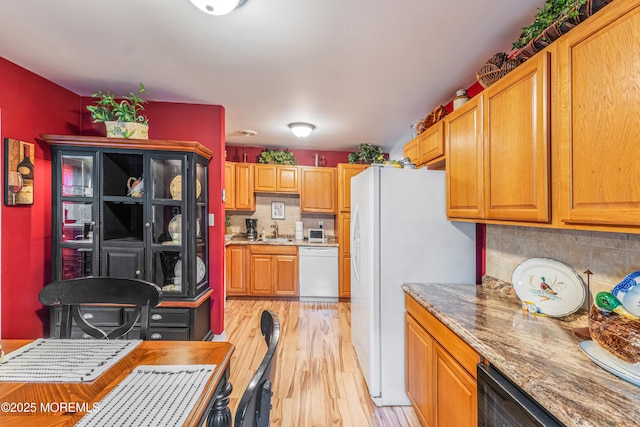 kitchen with white appliances, tasteful backsplash, light hardwood / wood-style floors, and sink