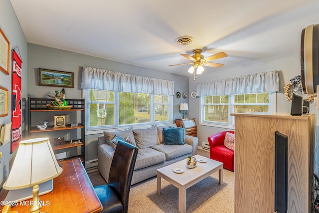 living room with baseboard heating, ceiling fan, and carpet flooring