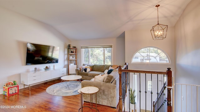 living room featuring wood-type flooring, lofted ceiling, and a chandelier