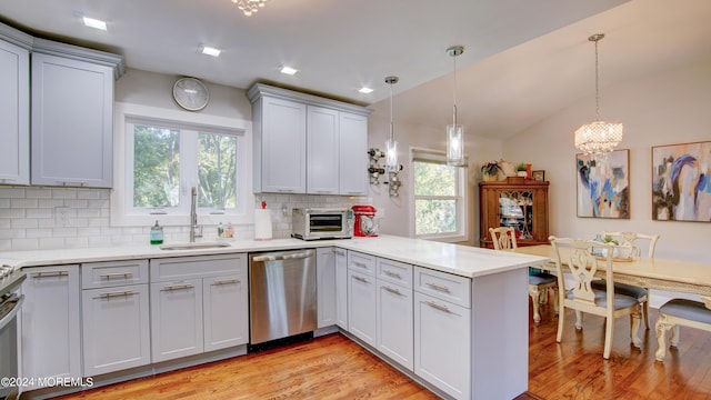 kitchen with sink, stainless steel dishwasher, kitchen peninsula, pendant lighting, and decorative backsplash