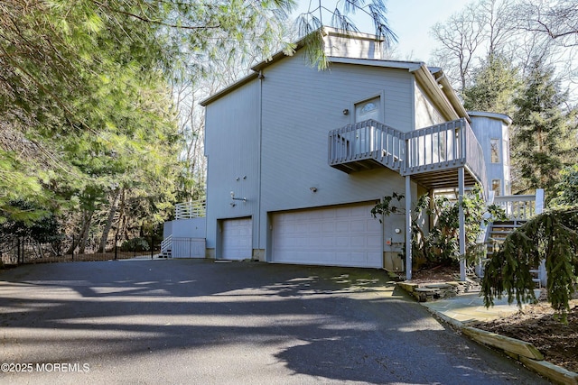 view of property exterior featuring a balcony and a garage