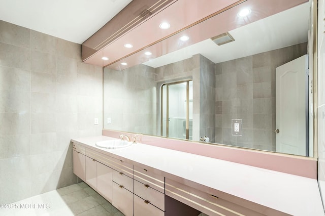 bathroom with tile patterned flooring, vanity, and tile walls