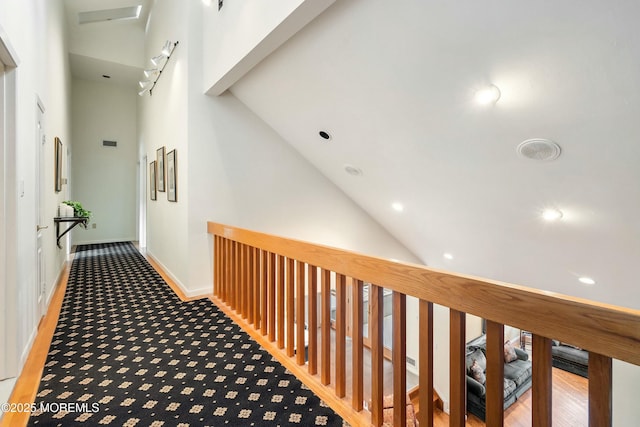 hall featuring carpet floors and high vaulted ceiling