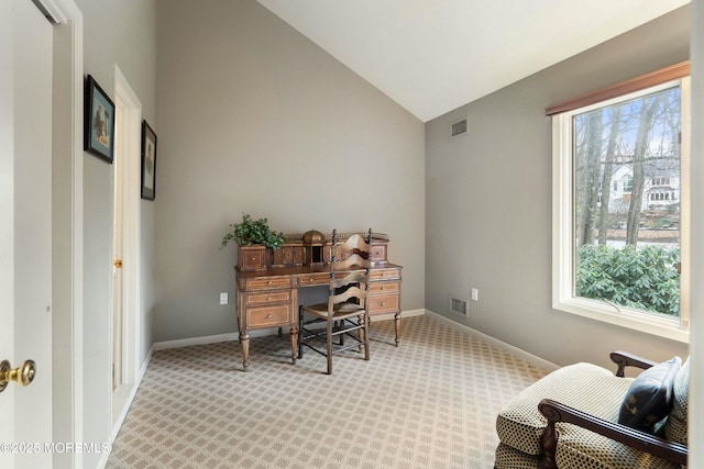 carpeted office space featuring vaulted ceiling and a healthy amount of sunlight