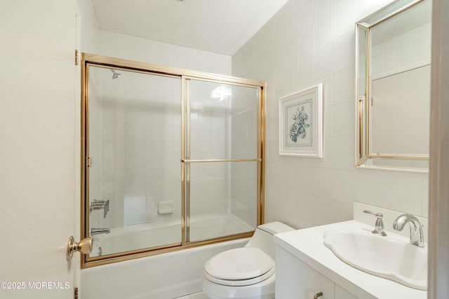 full bathroom with vanity, toilet, tile walls, and enclosed tub / shower combo