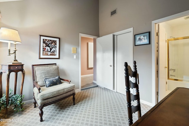 sitting room featuring carpet flooring and a high ceiling