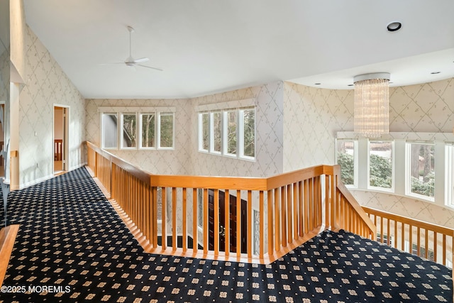 hall featuring carpet, plenty of natural light, and a chandelier