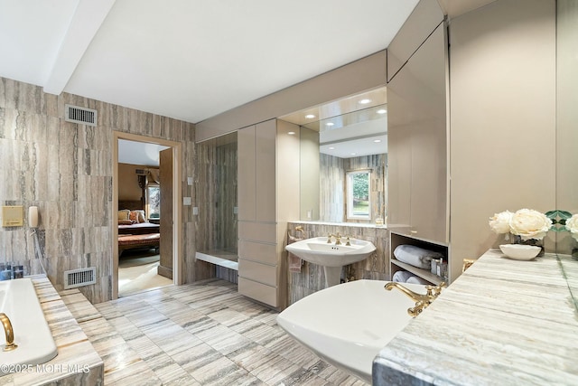 bathroom featuring beamed ceiling, tile walls, and sink