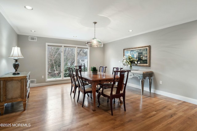 dining space with hardwood / wood-style floors and ornamental molding