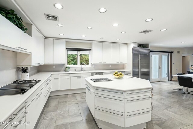 kitchen featuring gas cooktop, high end refrigerator, french doors, sink, and white cabinets