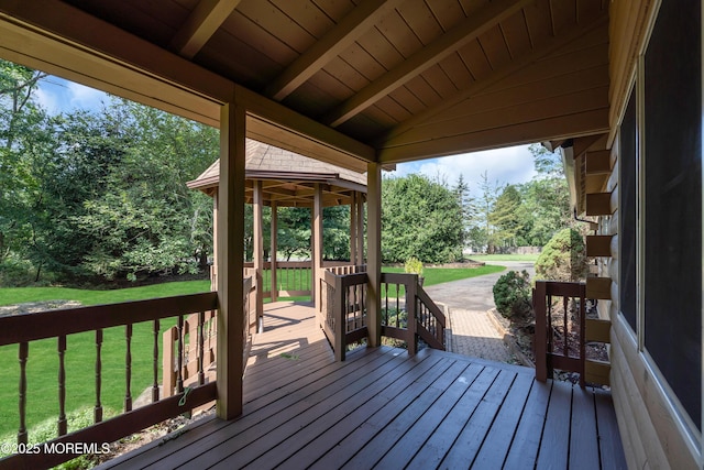 wooden deck featuring a lawn and a gazebo