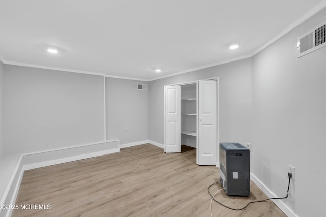 unfurnished bedroom featuring light hardwood / wood-style floors, crown molding, and a closet