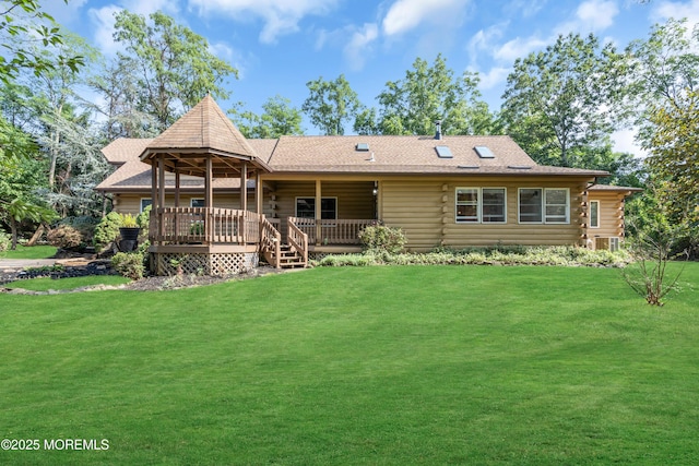 rear view of property with a yard and a deck