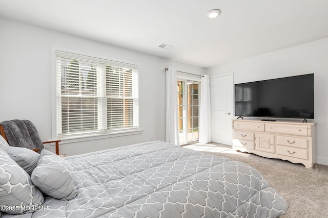 bedroom with access to outside, visible vents, and carpet flooring