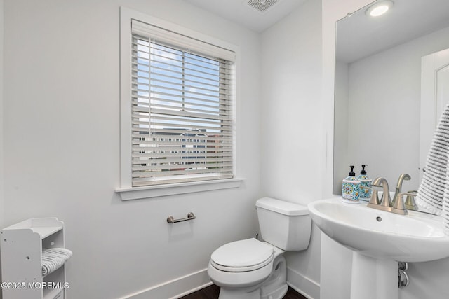 bathroom with visible vents, a sink, toilet, and baseboards