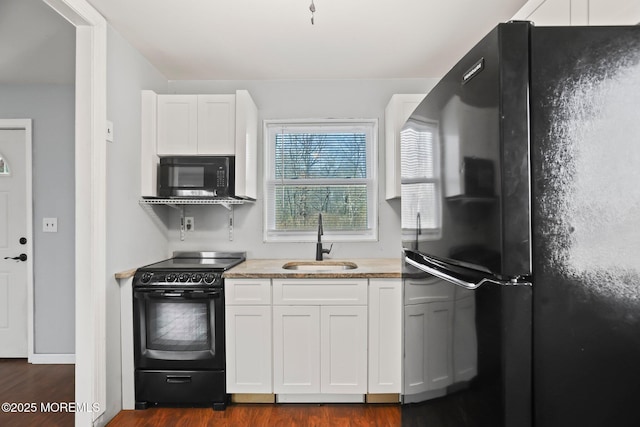 kitchen with white cabinets, dark hardwood / wood-style flooring, sink, and black appliances