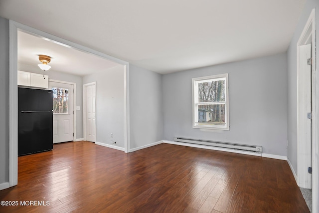 unfurnished room with dark hardwood / wood-style flooring and a baseboard heating unit