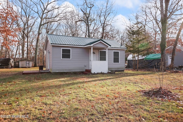 view of front facade with a storage shed and a front yard